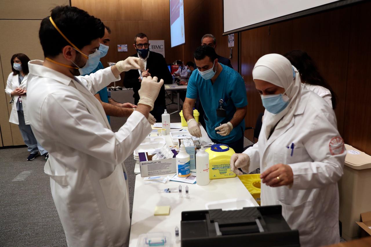 Medical works prepare syringes of the Pfizer-BioNTech Covid-19 vaccine during a nationwide vaccination programme at the American University Medical Center in Beirut, Lebanon, Feb 14. The Lebanese government, with the help of international agencies, provides free jabs of the Pfizer or AstraZeneca vaccine on a priority basis. Photo: AP
