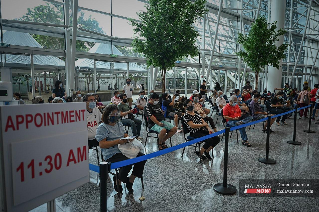 People wait to receive a dose of the Sinovac Covid-19 vaccine at the Mitec vaccination centre in Jalan Dutamas, Kuala Lumpur.