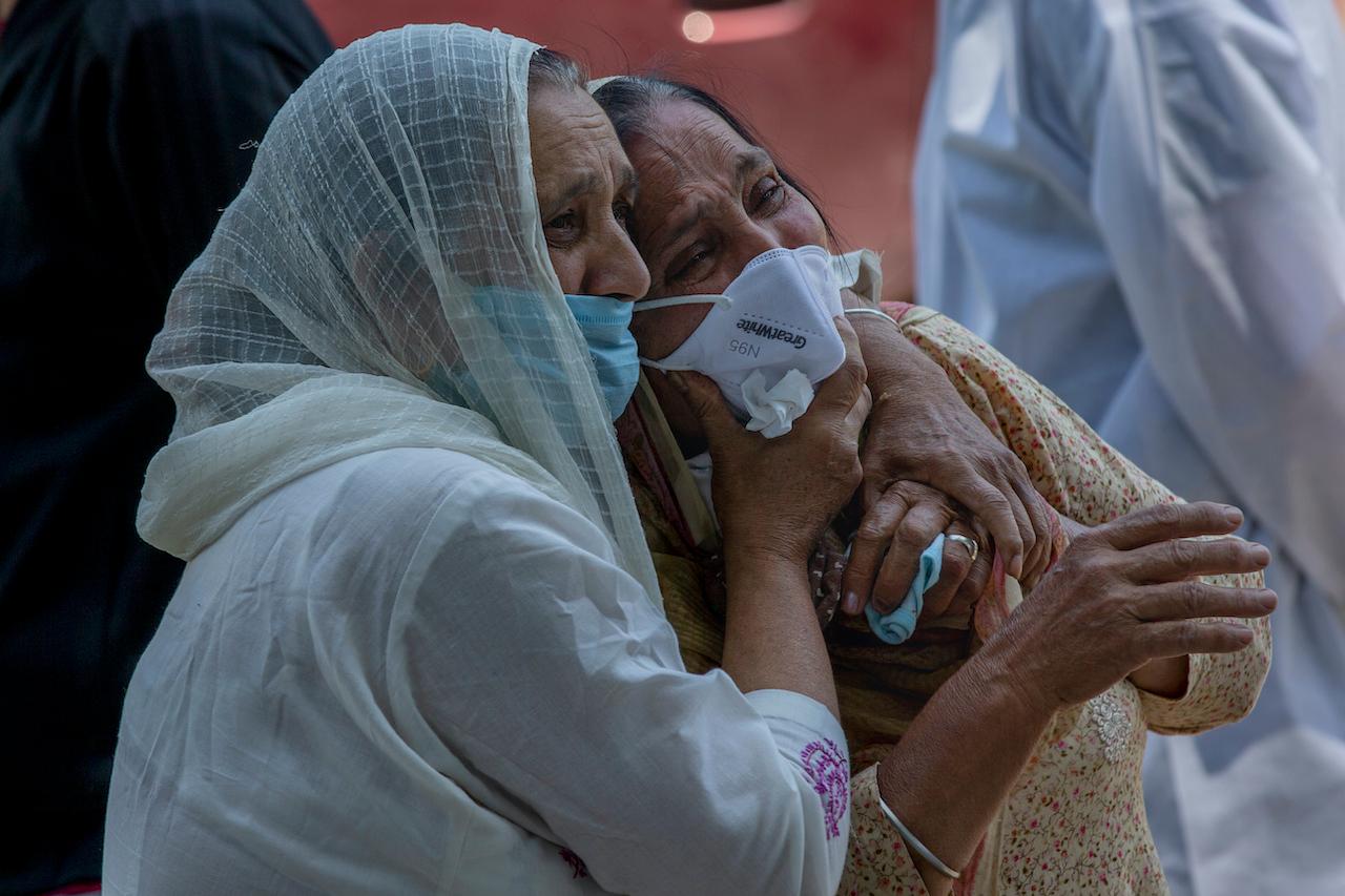 A relative comforts a grieving family member of a person who died of Covid-19, at a crematorium in Srinagar, Indian-controlled Kashmir, May 28. Photo: AP