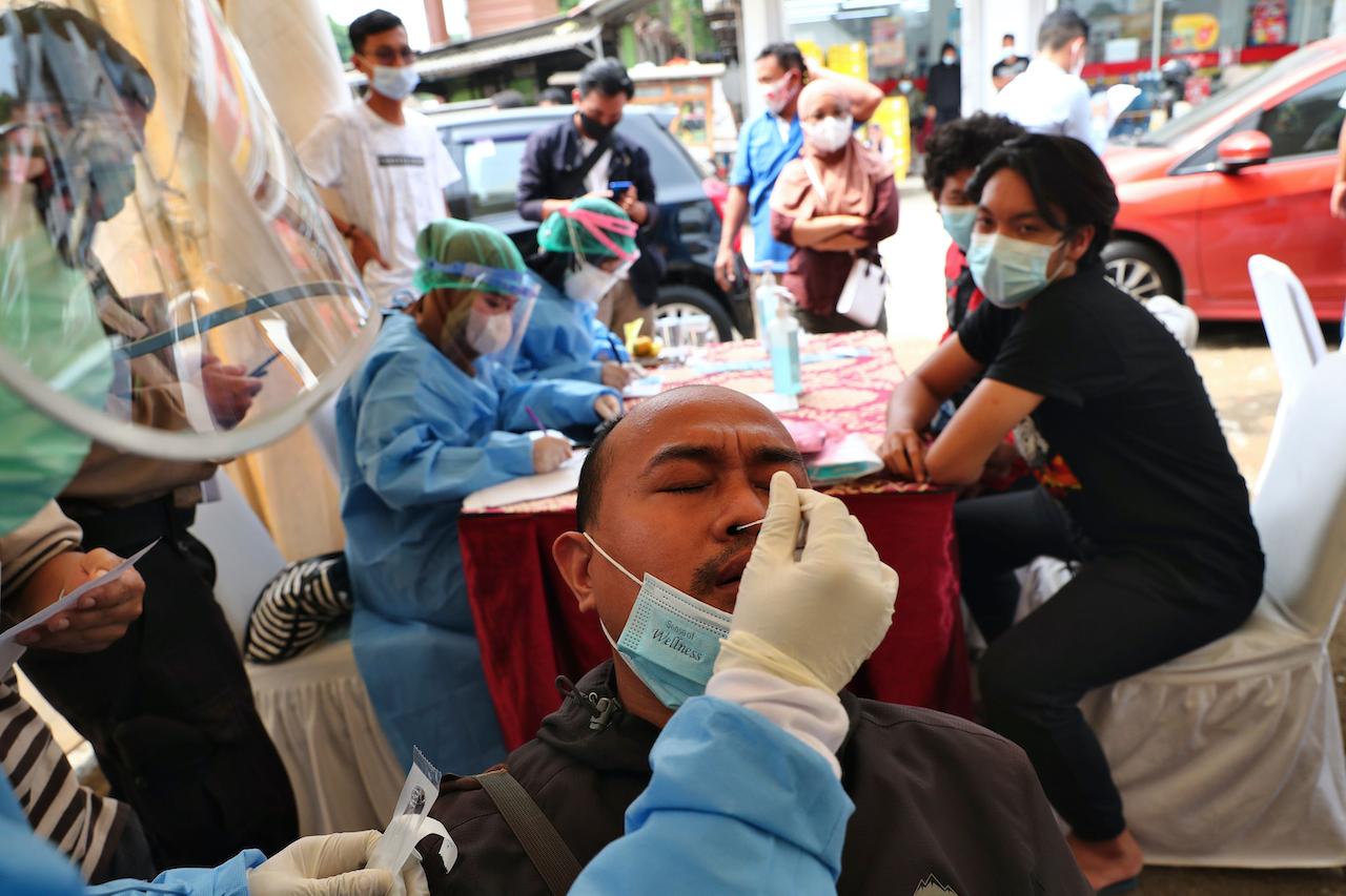 A traveller offers a nasal swab sample after returning from his Aidilfitri holiday before entering the capital city in an attempt to prevent spikes on Covid-19 cases, at a check point in Tangerang outside Jakarta, Indonesia, May 19. Photo: AP