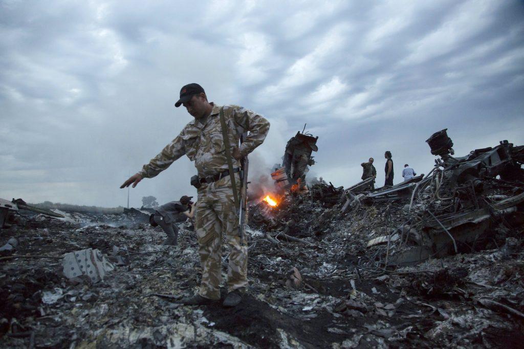 In this July 17, 2014 file photo, people walk in the debris at the crash site of MH17 near the village of Grabovo, Ukraine. Photo: AP