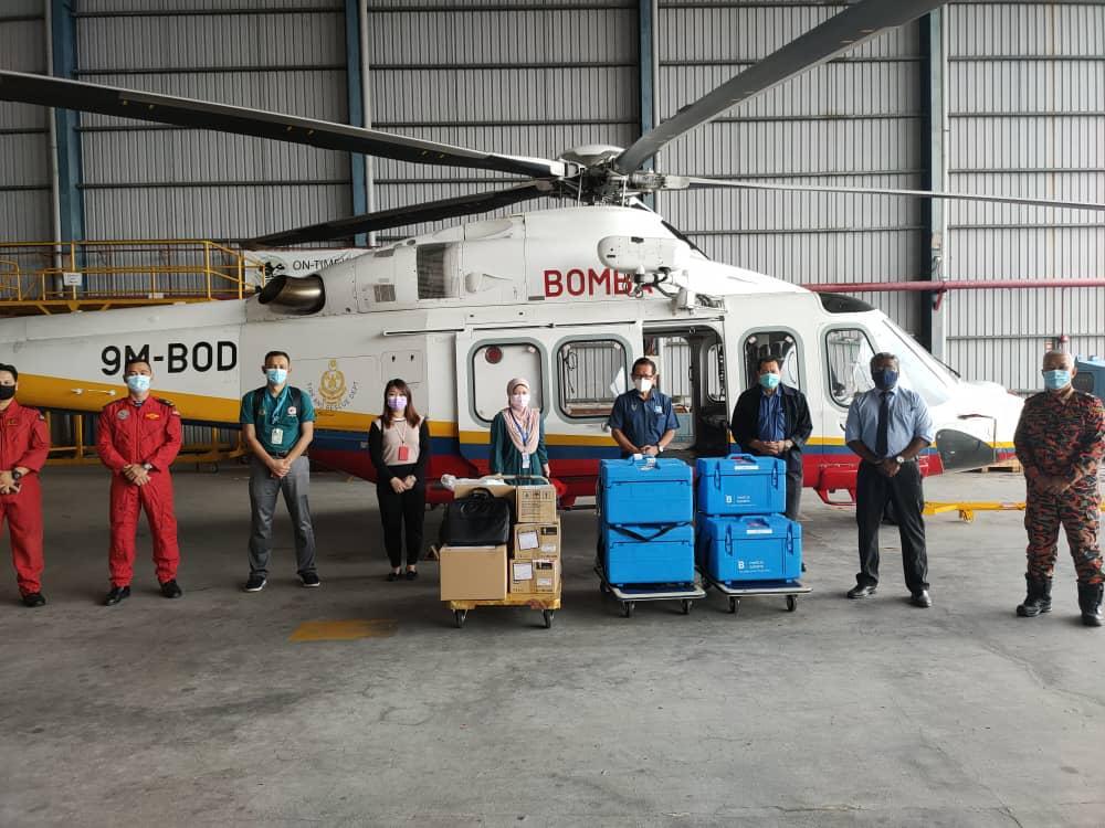 Transport Minister Lee Kim Shin (fourth left) with personnel from the fire department showing the supply of vaccine to be delivered by chopper to the interior of Miri today. Photo: Sarawak fire department