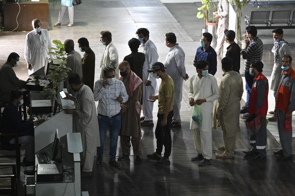 People stand in a queue to register to receive a dose of the Covid-19 Sinopharm vaccine at a vaccination centre in Rawalpindi today. Pakistan's Punjab province says it will block the mobile phones of people refusing to get Covid-19 jabs, in the latest move to penalise the unvaccinated in a country where only a fraction of the population have been inoculated. Photo: AFP