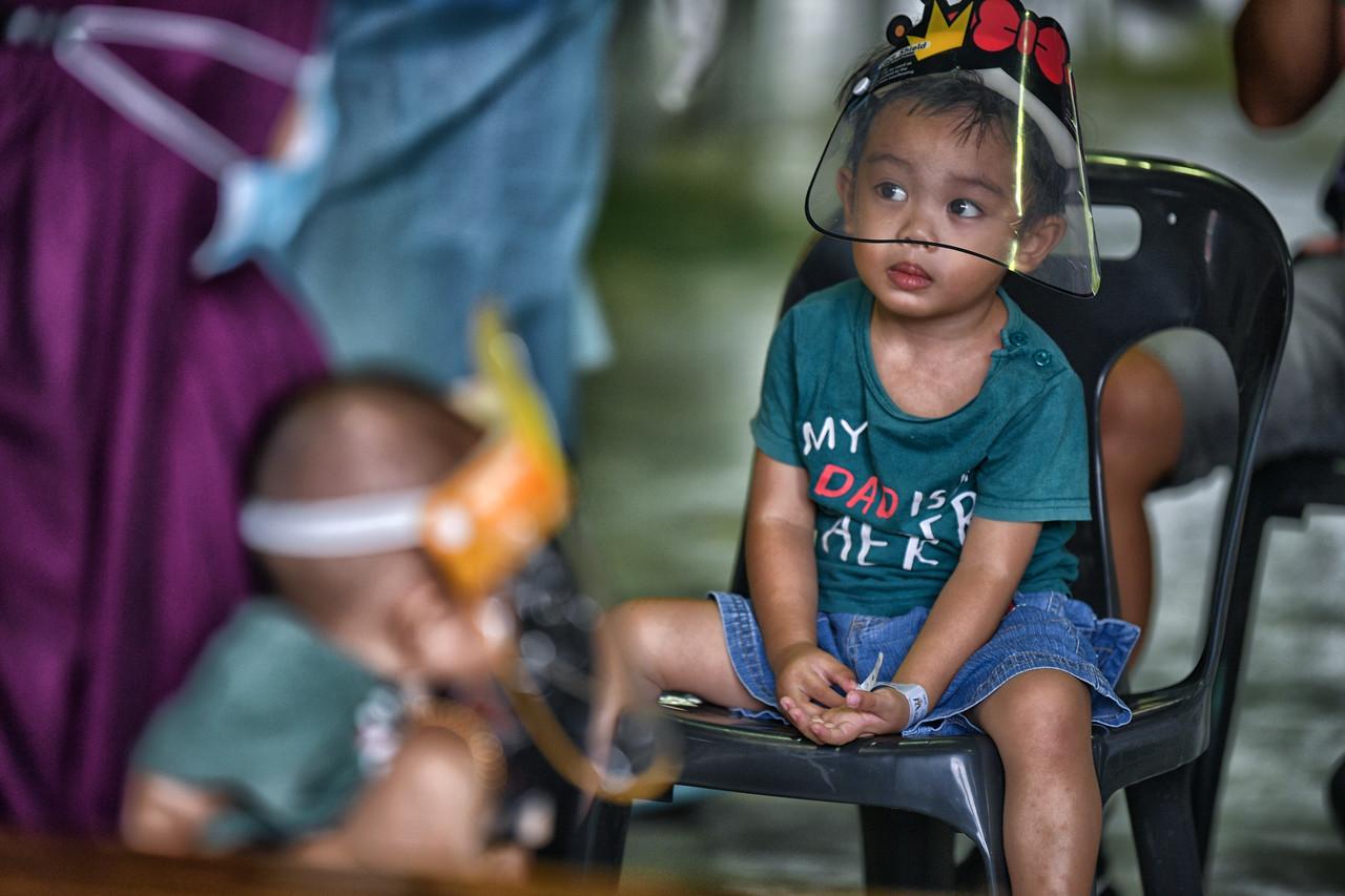 Children from Kampung Sinar Budi in Batu Kawa, Sarawak, which has been placed under enhanced movement control order, wait to be screened for Covid-19. Photo: Bernama