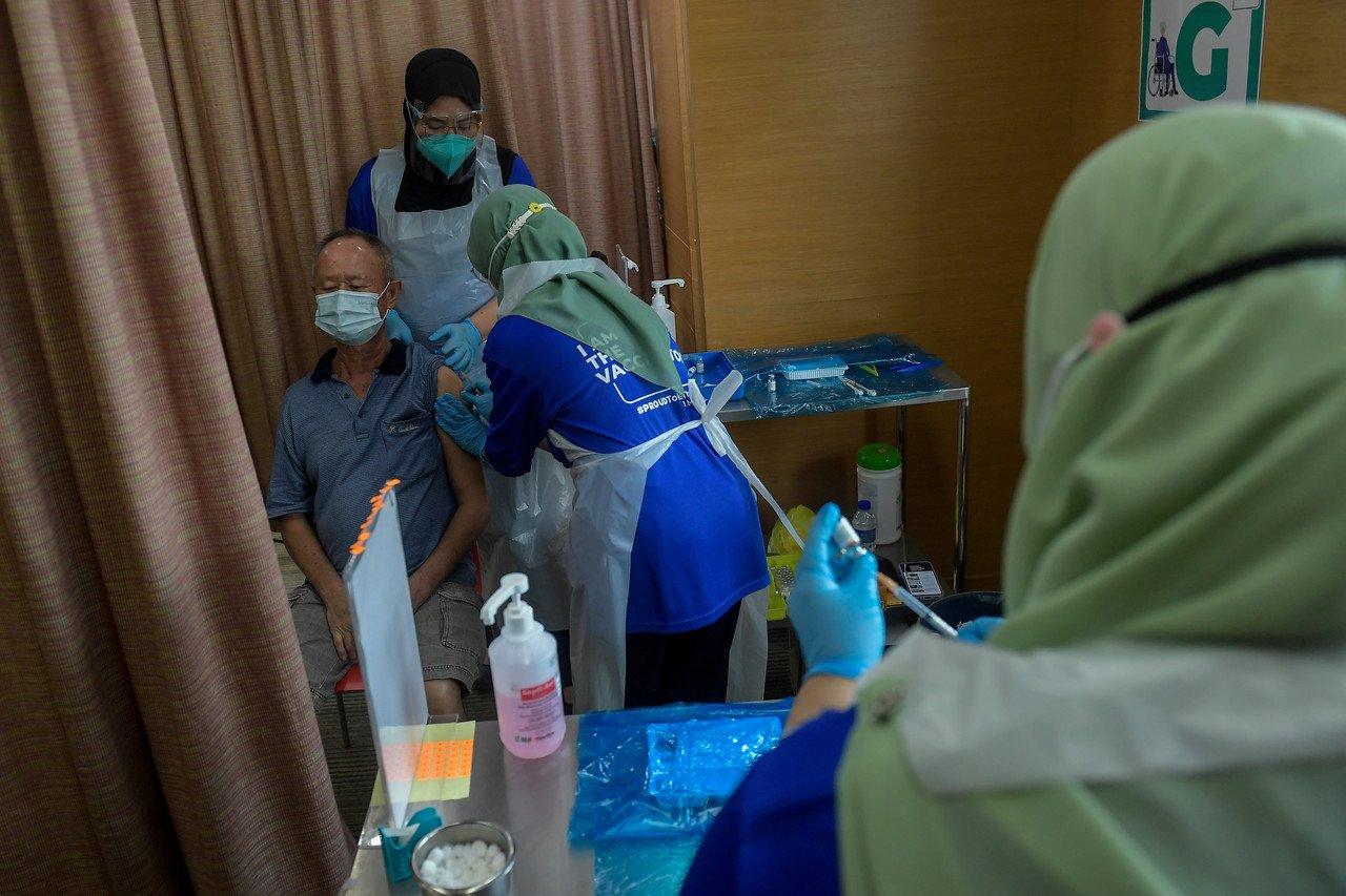 Health workers administer a Covid-19 jab to a senior citizen at the KPJ Tawakkal Kuala Lumpur specialist hospital. Photo: Bernama