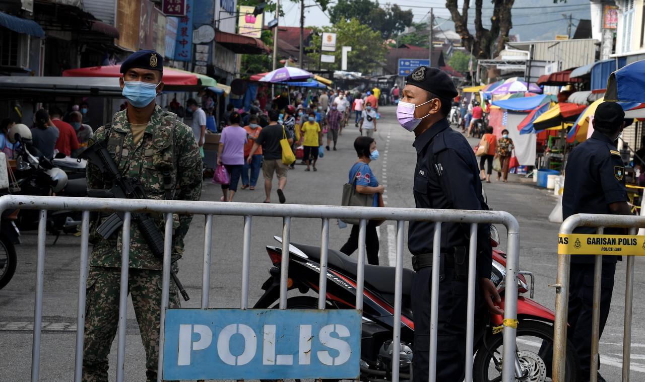 Personnel from the police and armed forces monitor SOP compliance at the Air Itam market in George Town, Penang, today. Photo: Bernama