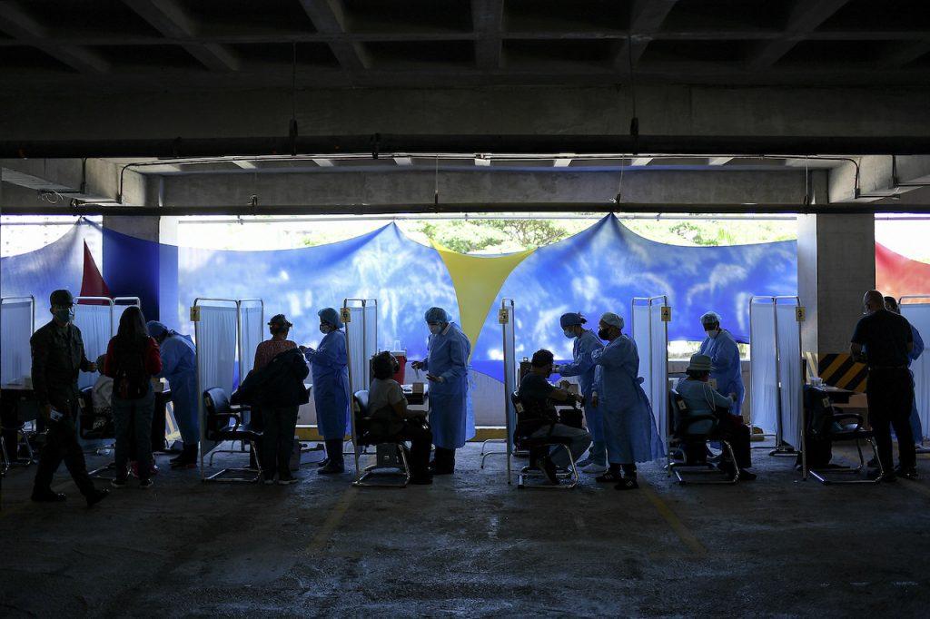Healthcare workers prepare doses of vaccine for Covid-19 at a vaccination centre set up in the parking lot of the Armed Forces Social Prevision Institute in Caracas, Venezuela, June 7. Photo: AP