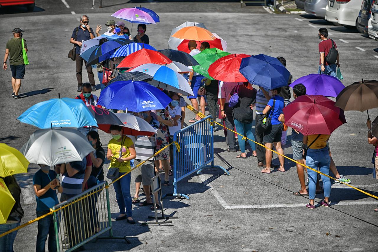 People wait in line to receive a dose of the Pfizer Covid-19 vaccine at the Stadium Perpaduan Negeri Petra Jaya vaccination centre in Kuching. Photo: Bernama