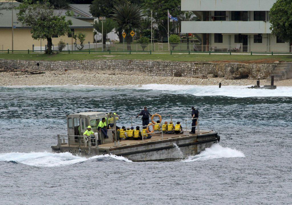 A group of asylum seekers are taken by barge to a jetty on Australia's Christmas Island in this April 14, 2013 file photo.