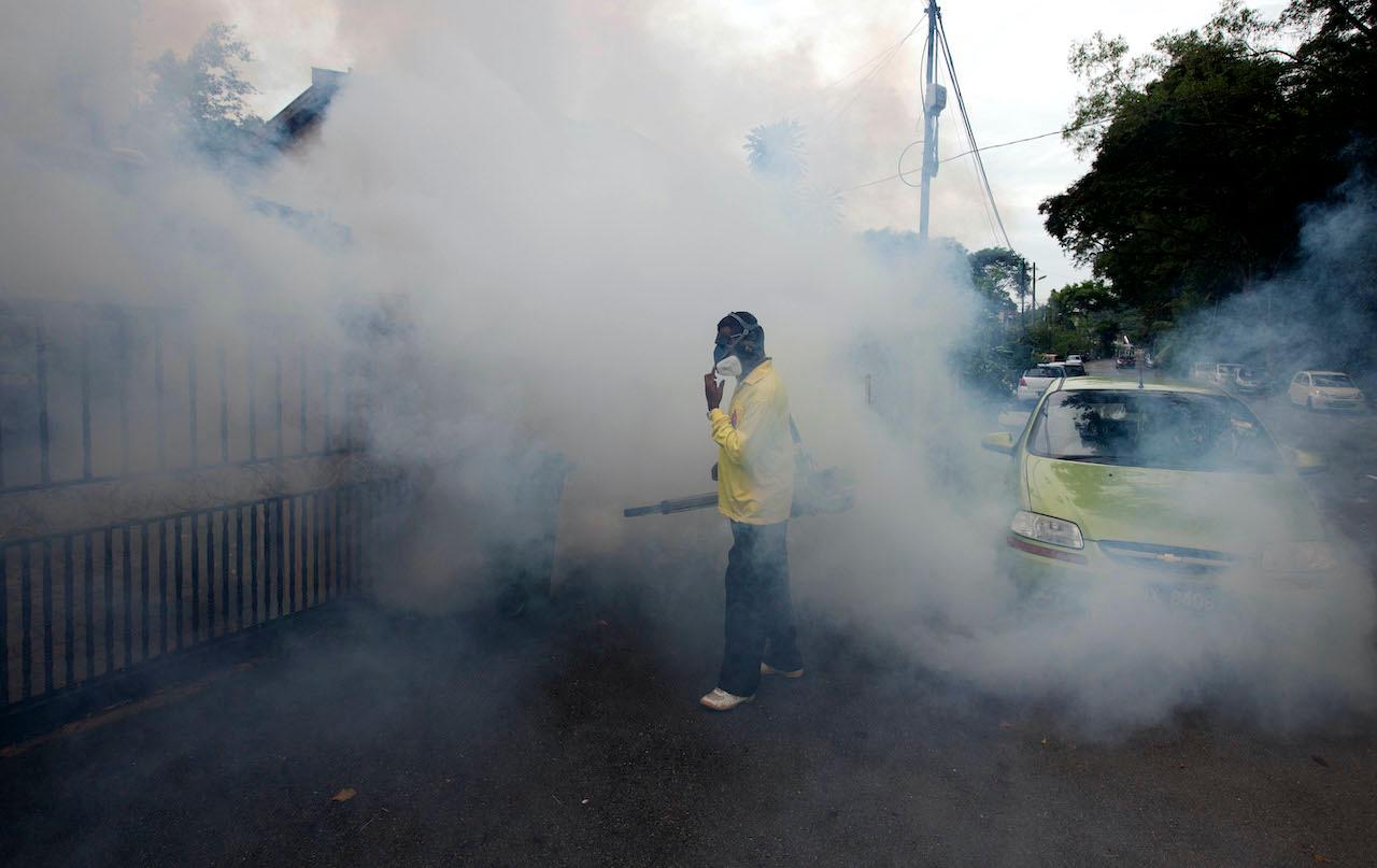 Municipal workers perform fogging to eradicate Aedes mosquito breeding grounds to prevent the spread of dengue fever in Kuala Lumpur, July 4, 2012. Photo: AP