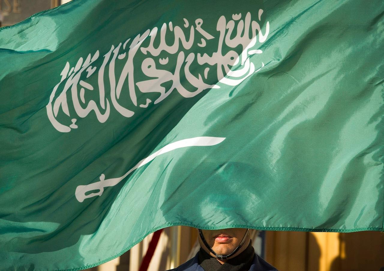 In this March 22, 2018, file photo, an honour guard member is covered by the flag of Saudi Arabia in Washington. Saudi Arabia executed a young man on June 15 who was convicted on charges stemming from his participation in an anti-government rebellion by minority Shiites. Photo: AP