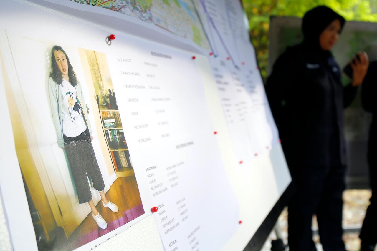A police officer stands near a photo of French-Irish teenager Nora Anne Quoirin in Seremban, Negeri Sembilan, Aug 8, 2019. Photo: AP