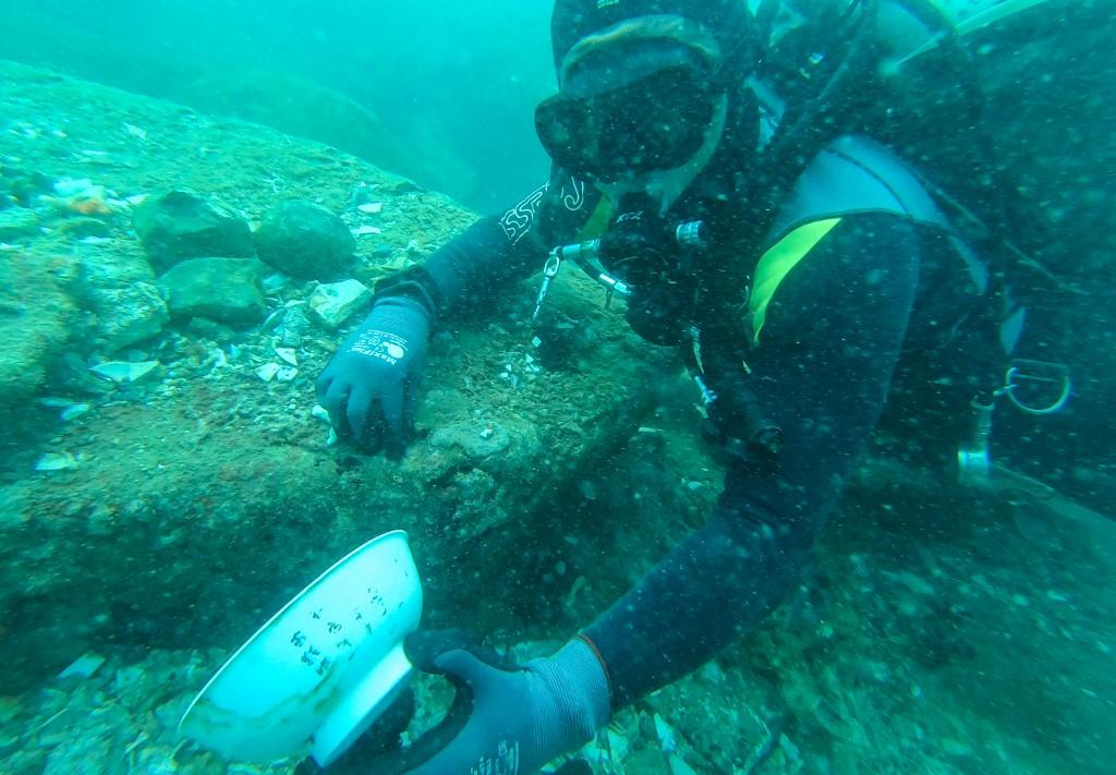 This undated handout photo from the Iseas-Yusof Ishak Institute released on June 16 shows a diver holding a bowl with Chinese characters that was discovered from a shipwreck in the waters off Pedra Branca, Singapore. Photo: AFP