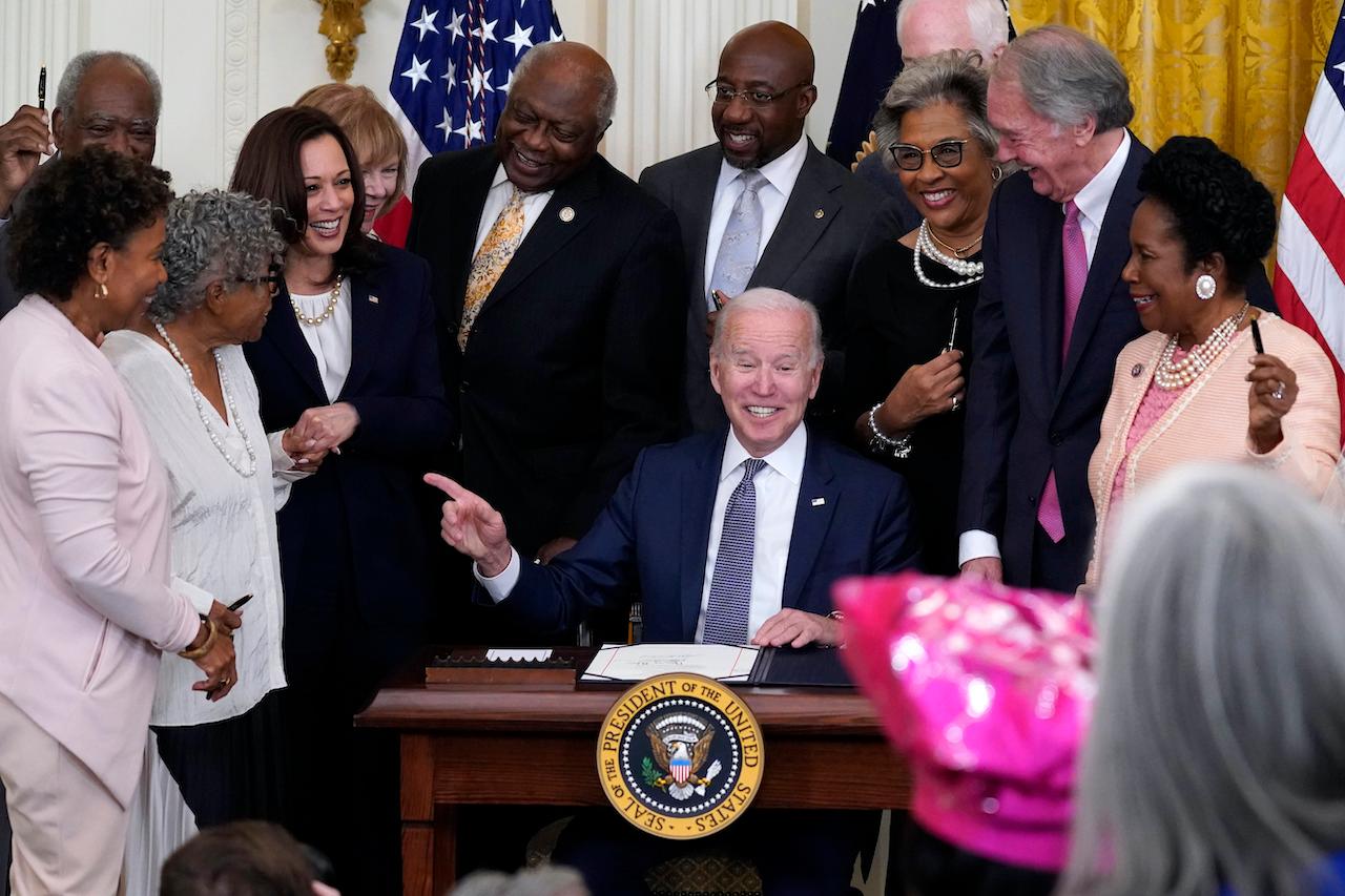 President Joe Biden points after signing the Juneteenth National Independence Day Act, in the East Room of the White House in Washington with representatives and senators, June 17. Photo: AP