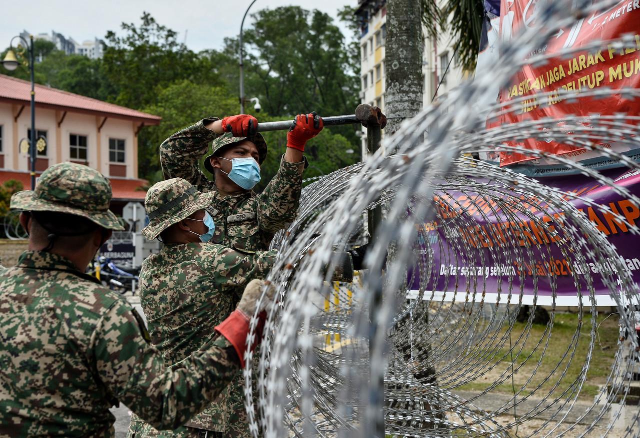 Armed forces personnel put up a barbed wire fence around the Desa Rejang public housing area in Kuala Lumpur which has been placed under enhanced movement control order until July 1. Photo: Bernama