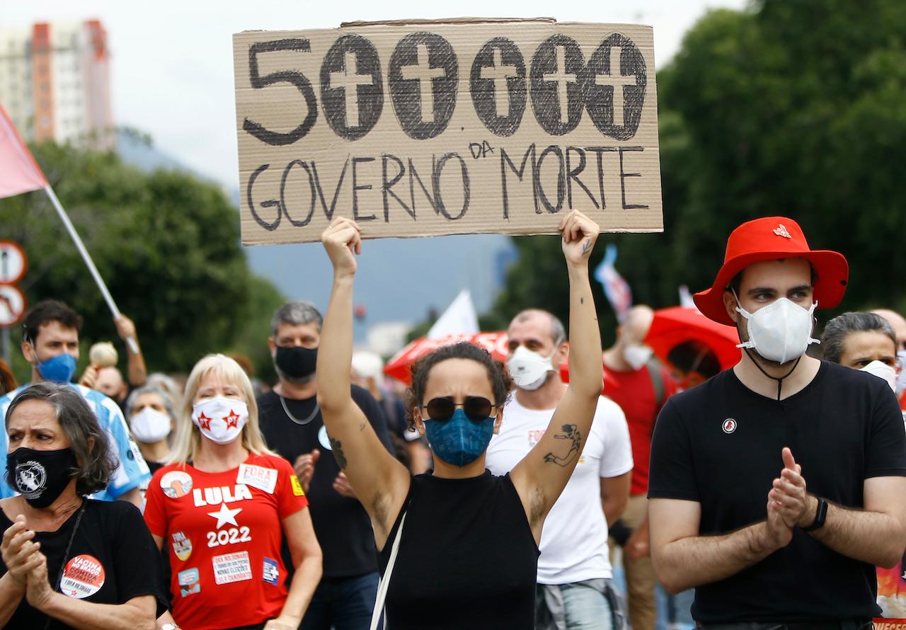 A woman wearing a face mask holds a sign that reads in Portuguese: '500,000, government of death' during a protest against Brazilian President Jair Bolsonaro's handling of the coronavirus pandemic and economic policies which they say harm the interests of the poor and working class, in Rio de Janeiro, Brazil, June 19. Photo: AP
