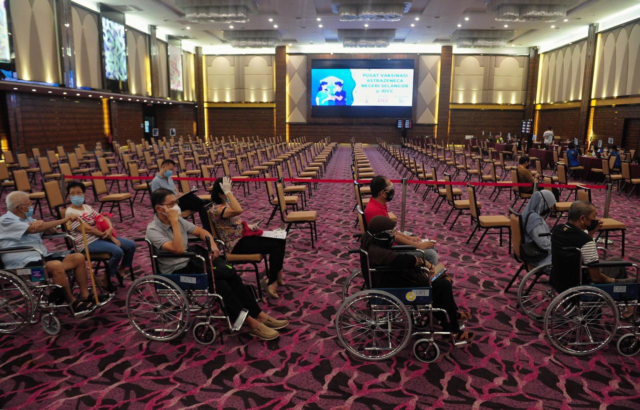 Senior citizens accompanied by family members at a special lane for those in wheelchairs at the IDCC vaccination centre in Shah Alam. Photo: Bernama