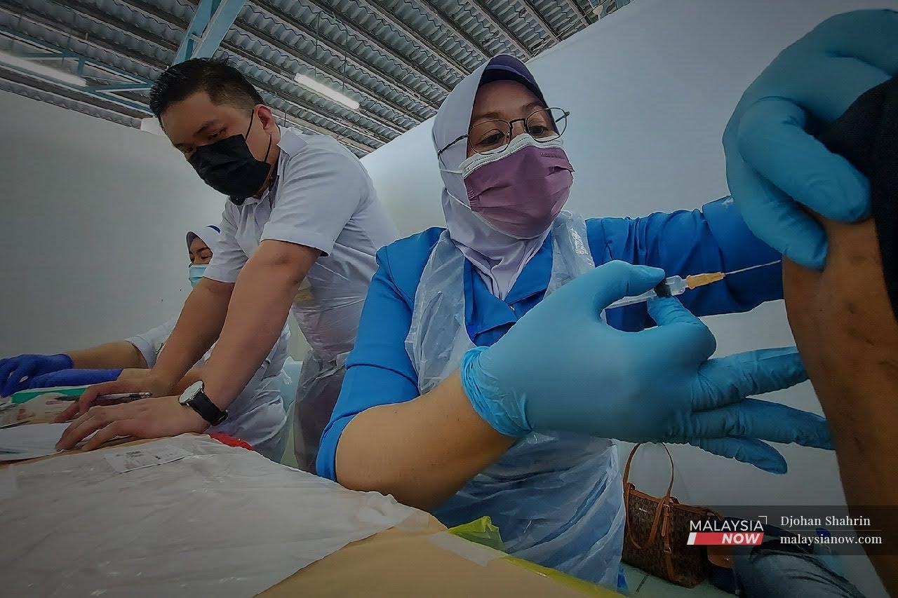 Petugas kesihatan dari Pusat Kesihatan Tangling memberikan suntikan vaksin dos kedua  kepada penghuni Pusat Transit Gelendangan Kuala Lumpur di Anjung Kelana, Taman Desa. Pembangunan vaksin mRNA di Malaysia sudah bermula November tahun lalu dan kini dalam peringkat pembuktian konsep.