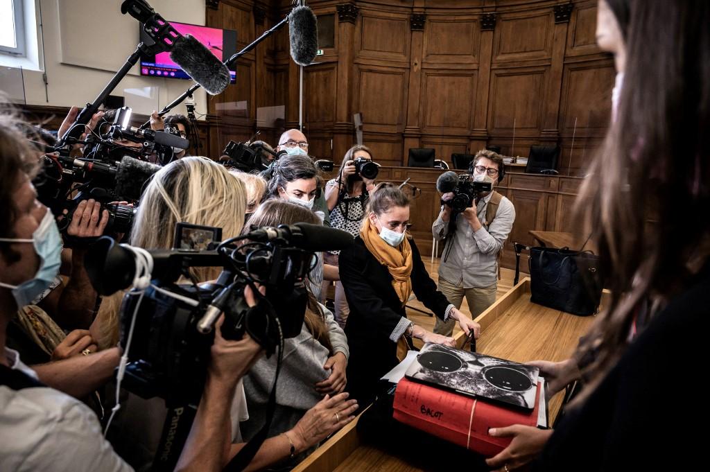 Valerie Bacot (centre, yellow scarf) arrives flanked by her family and surrounded by journalists at the Chalon-sur-Saone Courthouse, central-eastern France, prior to the opening hearing of her trial on charges of murdering her stepfather-turned-husband, on June 21. Photo: AFP