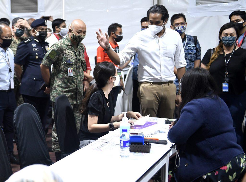 Menteri Penyelaras Imunisasi Covid-19 Kebangsaan Khairy Jamaluddin berbual dengan orang ramai di Stadium Nasional Bukit Jalil hari ini. Gambar: Bernama