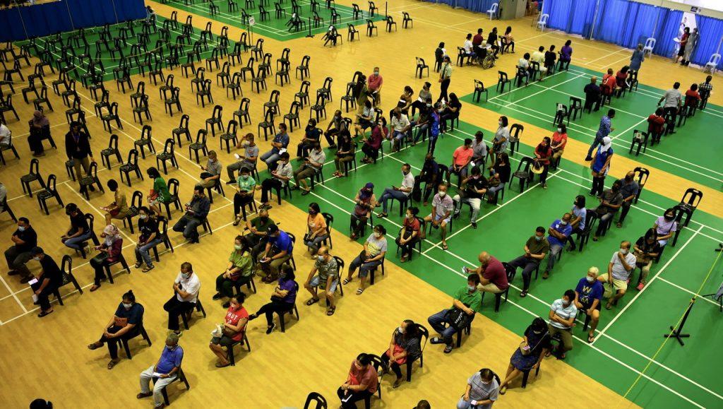 People wait for their turn to be vaccinated at the Dewan Millennium vaccination centre in Kepala Batas. Photo: Bernama