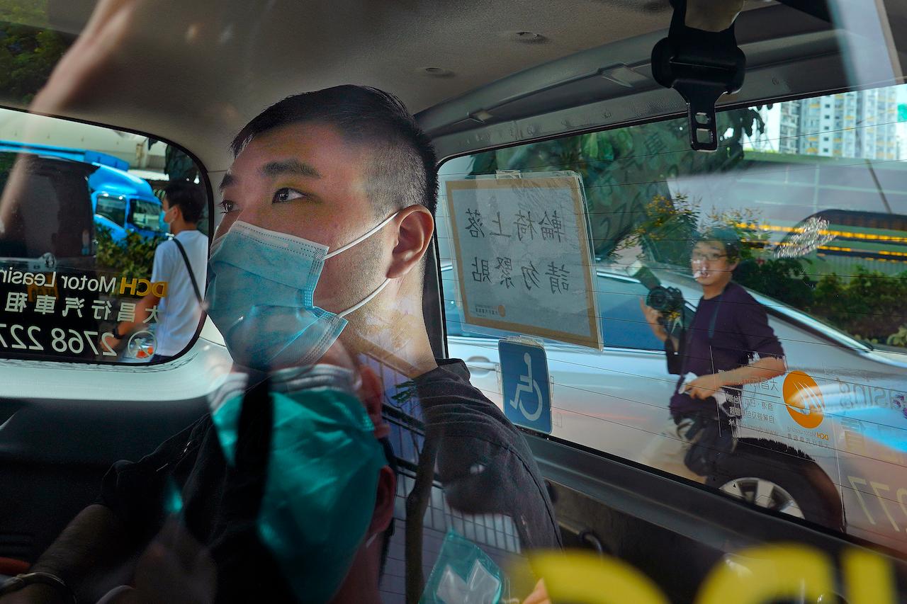 In this July 6, 2020, file photo, Tong Ying-kit arrives at a court in a police van in Hong Kong. Tong, accused of driving a motorcycle into police officers while carrying a Hong Kong protest flag today became the first person to stand trial under the national security law implemented last year. Photo: AP