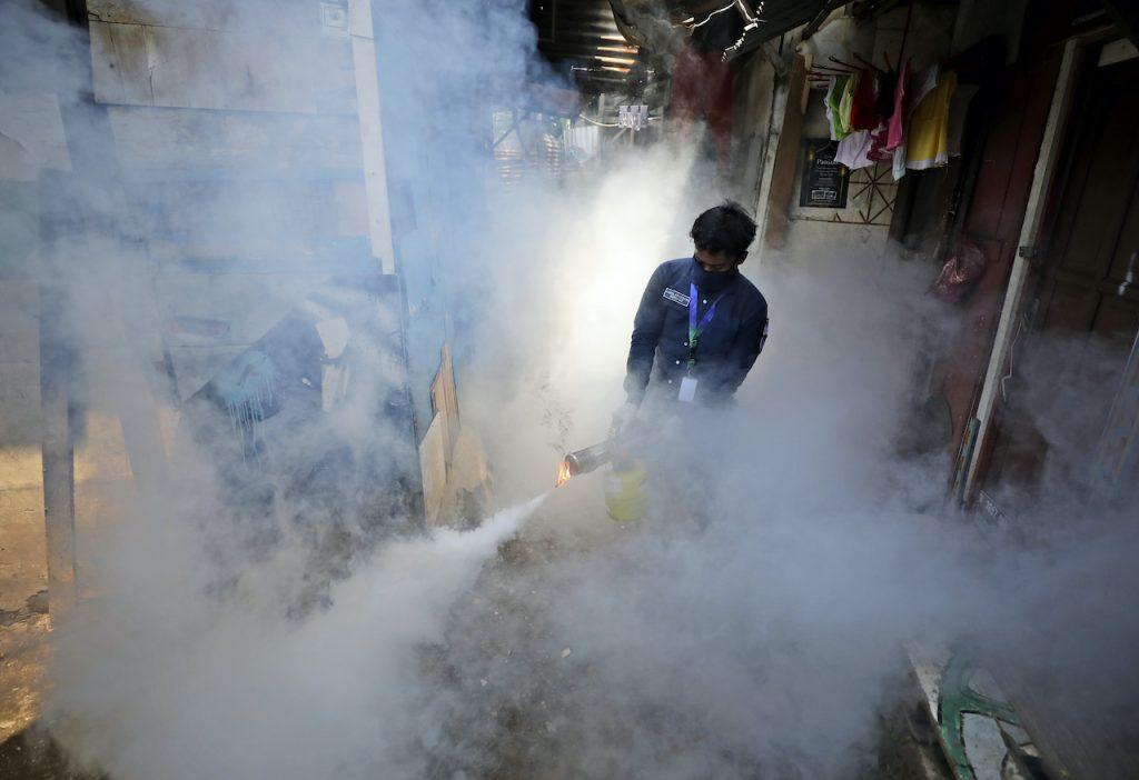 A worker fumigates a slum to prevent an outbreak of dengue fever in Jakarta, Indonesia, April 22, 2020. Photo: AP
