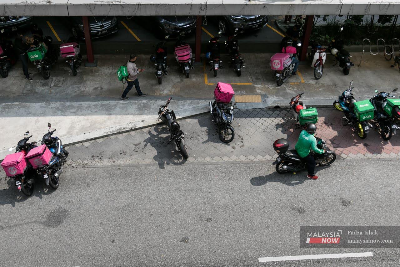 Food delivery rides wait outside a mall in Kuala Lumpur.