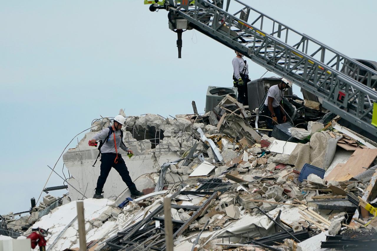 Rescue workers walk amid the rubble of a 12-story beachfront condo building which collapsed in the Surfside area of Miami, Florida, June 24. Photo: AP