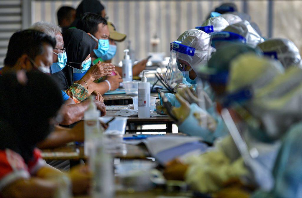 Pemeriksaan kesihatan oleh petugas kesihatan di kawasan yang dikenakan PKPD di Kampung Sinar Budi, Batu Kawa, Sarawak. Gambar: Bernama