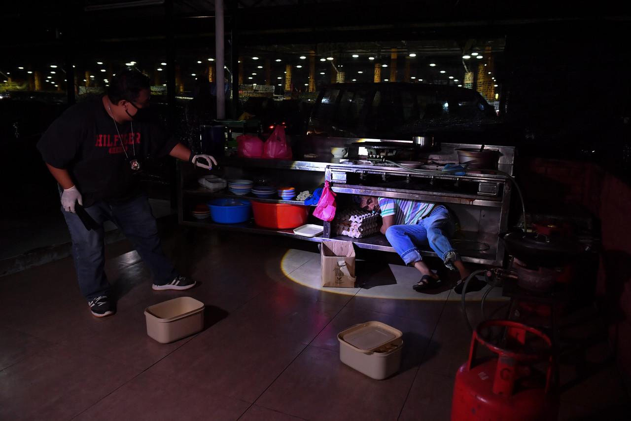Seorang anggota Jabatan Imigresen Malaysia berjaya menahan seorang pekerja asing yang cuba bersembunyi semasa serbuan Ops Patuh di pasar borong Selangor, Seri Kembangan awal pagi tadi. Gambar: Bernama