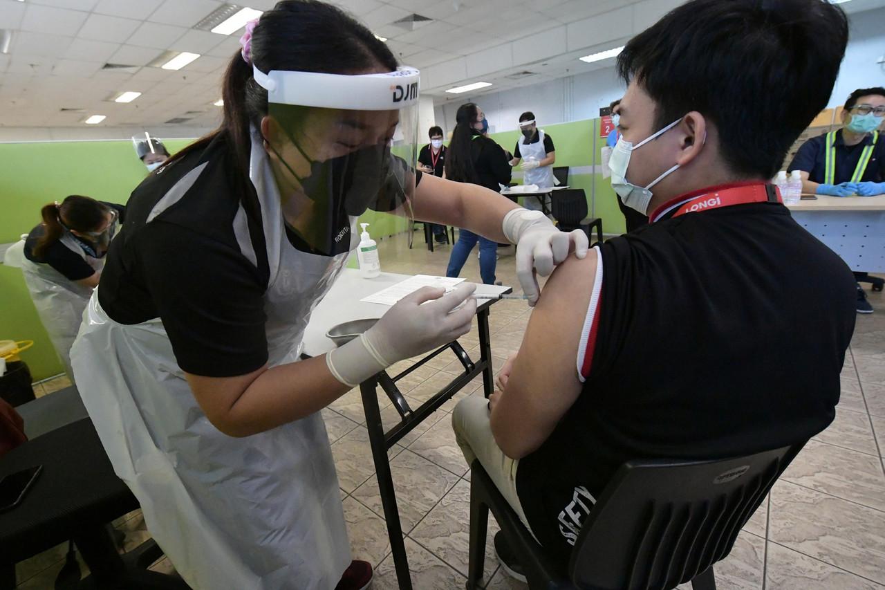 A health worker administers a dose of Sinovac vaccine to a factory worker in Kuching, Sarawak. Photo: Bernama