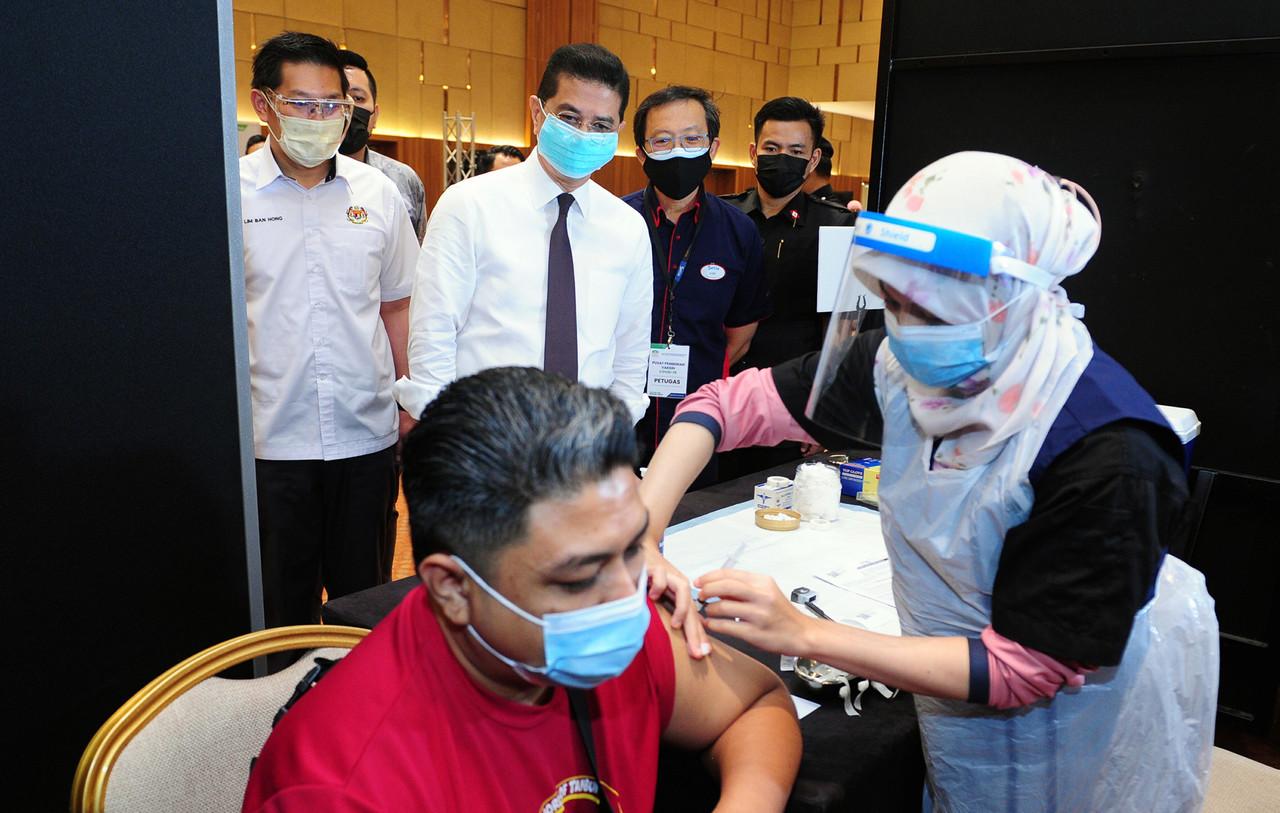International Trade and Industry Minister Mohamed Azmin Ali observes the vaccination process at the Setia City Convention Centre in Shah Alam today. Photo: Bernama