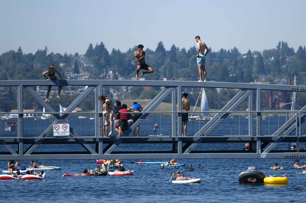 Two people jump from a pedestrian bridge into the water at Lake Union Park in Seattle  during a heat wave hitting the Pacific Northwest, June 27. Photo: AP