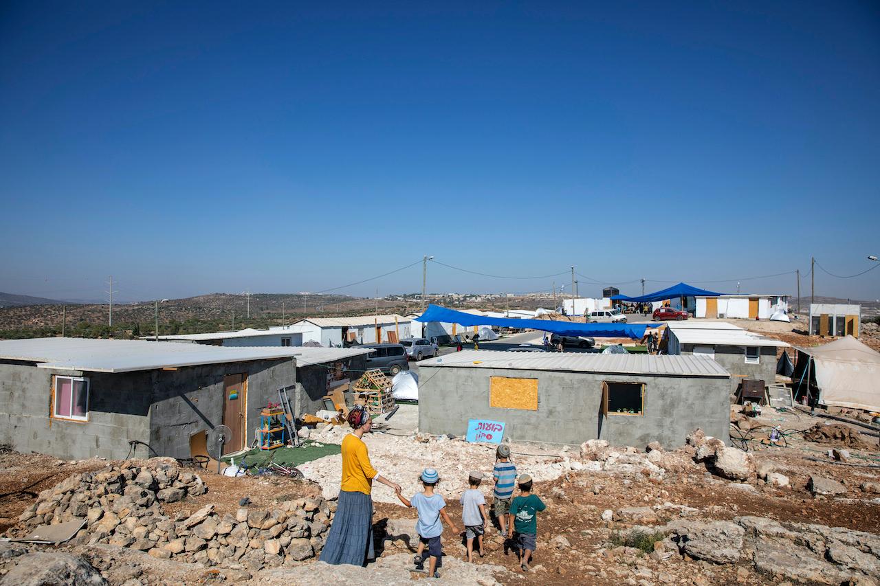 Israeli settlers walk at the recently established outpost of Eviatar, near the northern Palestinian West Bank town of Nablus, June 28. Photo: AP