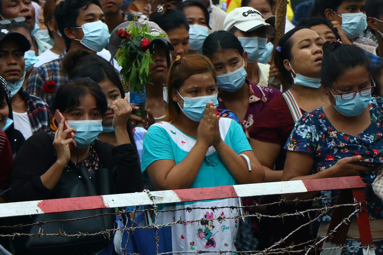 A woman gestures with her hands together while waiting with large crowds outside Insein Prison in Yangon, Myanmar, June 30. Photo: AP