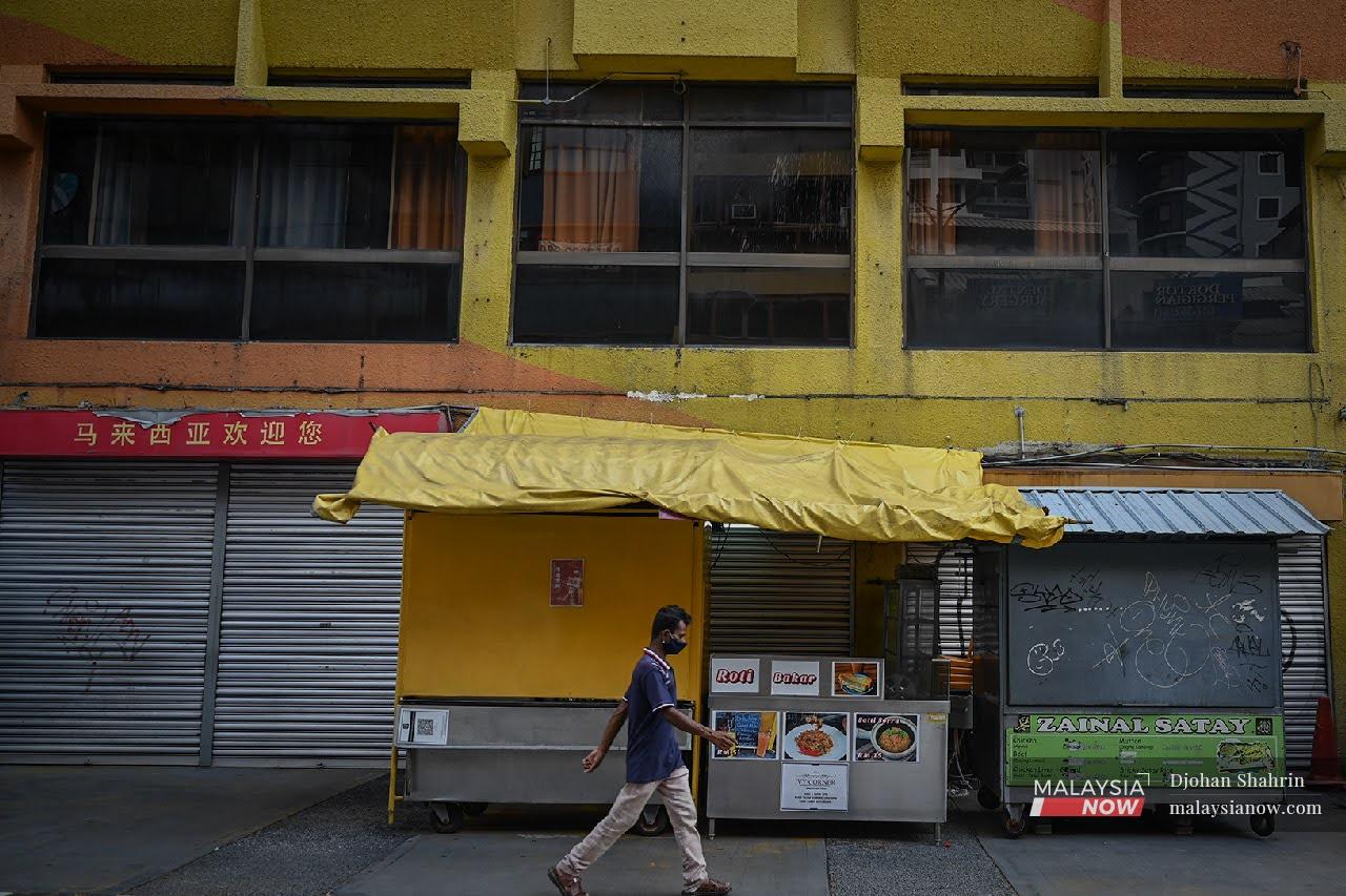 A man walks past a row of shops closed under the movement control order in Kuala Lumpur. Entertainment centres are among the businesses prohibited from operating during the lockdown period.