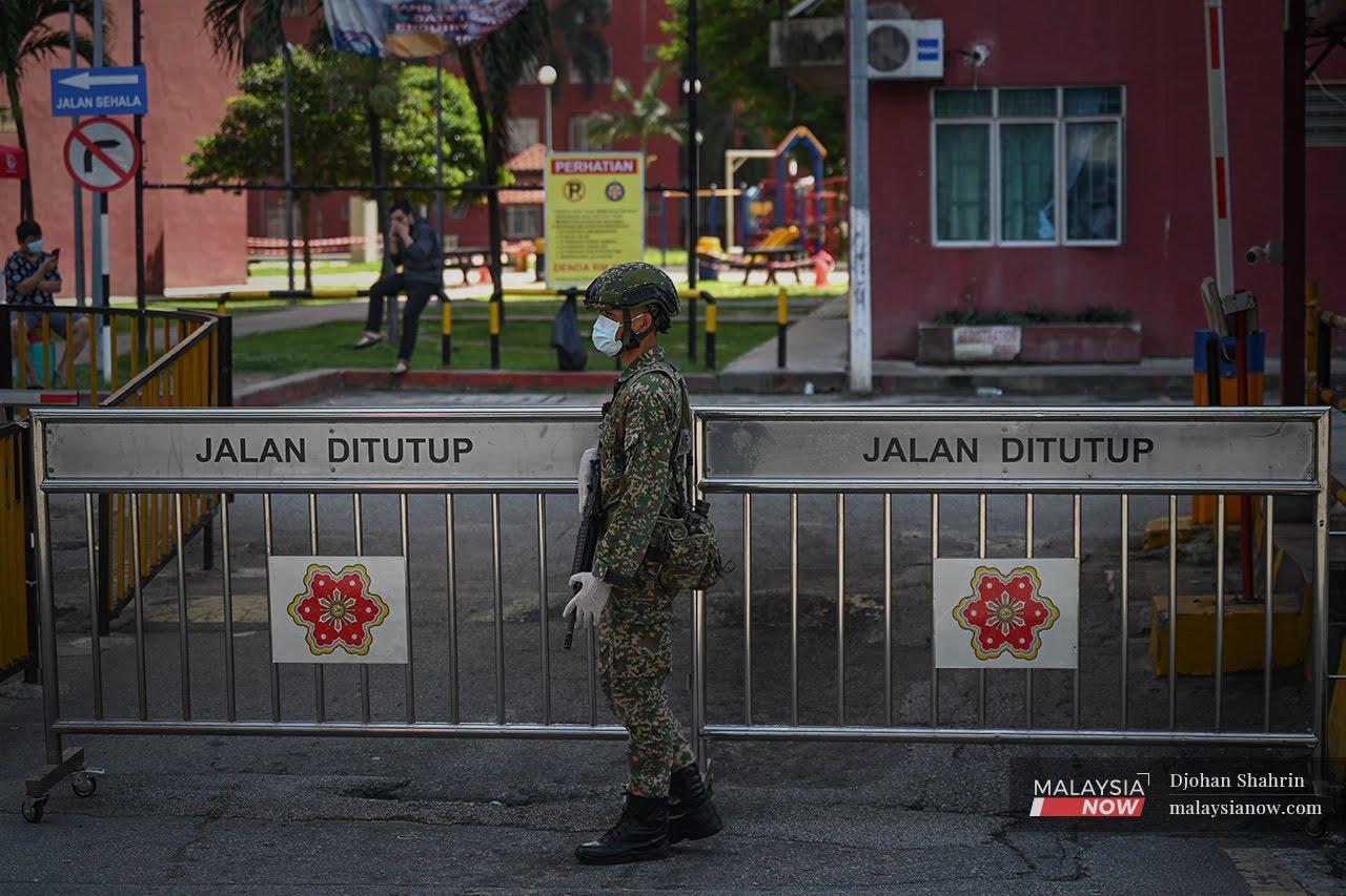 Seorang anggota tentera berdiri di pintu utama Pangsapuri Mentari Court, kawasan ini dikenakan perintah kawalan pergerakan diperketatkan di bawah Daerah Petaling Jaya. Hampir 50 kawasan di Selangor dan Kuala Lumpur diletakkan di bawah PKPD akibat peningkatan ke jangkitan Covid-19.