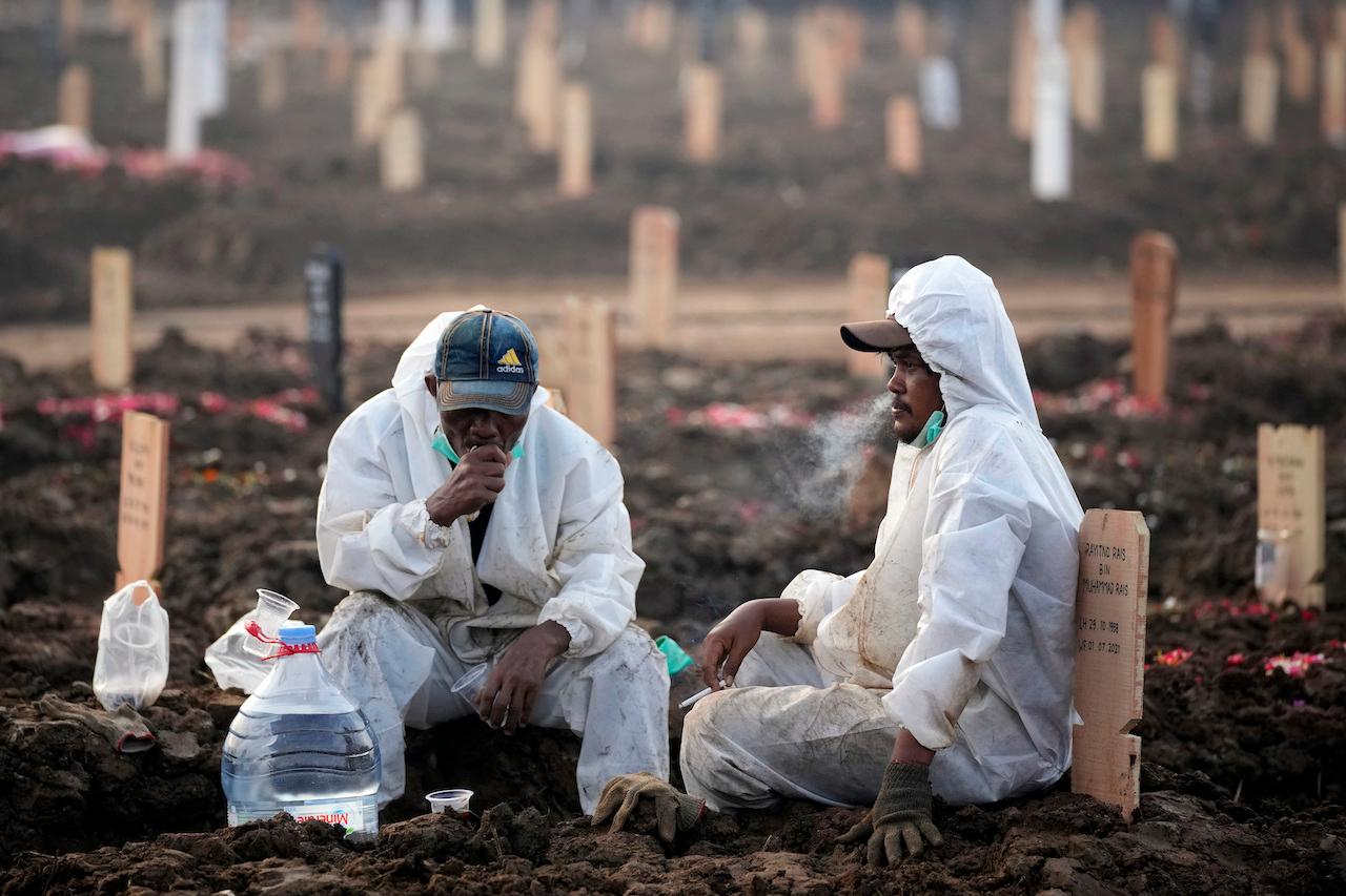Workers take a break during a busy day at Rorotan Cemetery, which is reserved for those who died of Covid-19, in Jakarta, Indonesia, July 1. Photo: AP
