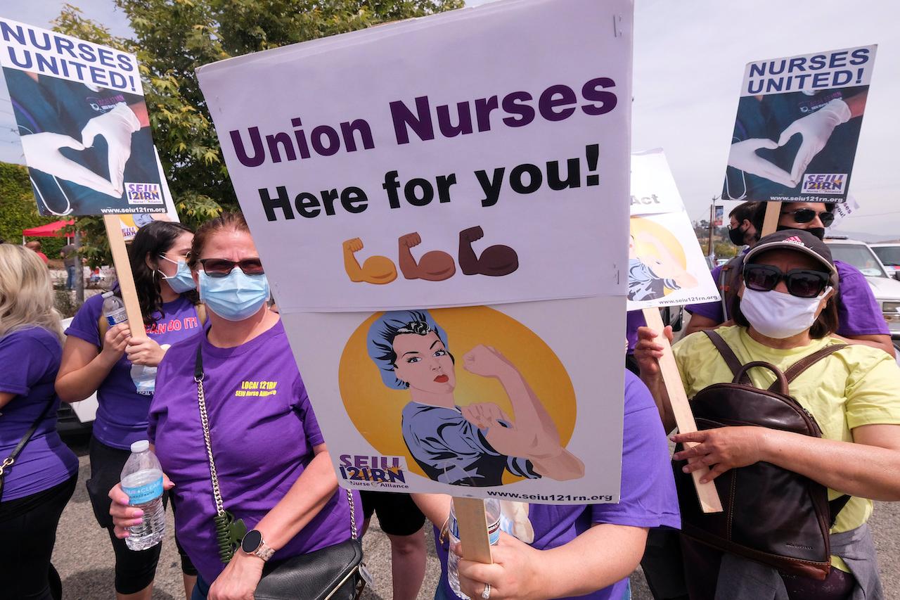 People wearing face masks and holding signs take part in the annual May Day marches downtown Los Angeles in this file photo dated May 1. Photo: AP