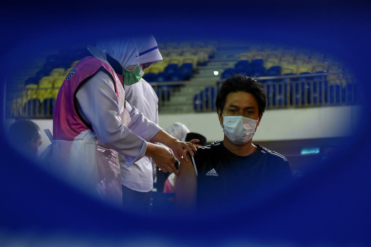 A visually impaired man receives a shot of Covid-19 vaccine at a vaccination centre in Kuala Nerus, Terengganu. Photo: Bernama