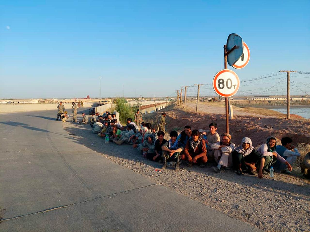 In this handout photo released by Border Troops of the State Committee for National Security of the Republic of Tajikistan on June 22, Afghanistan government soldiers sit at a bridge next to Tajikistan-Afghanistan border in Tajikistan. Photo: AP