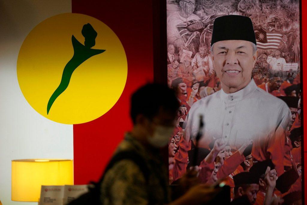 A man walks past a poster of Umno president Ahmad Zahid Hamidi at the party's headquarters in Kuala Lumpur. Photo: AP