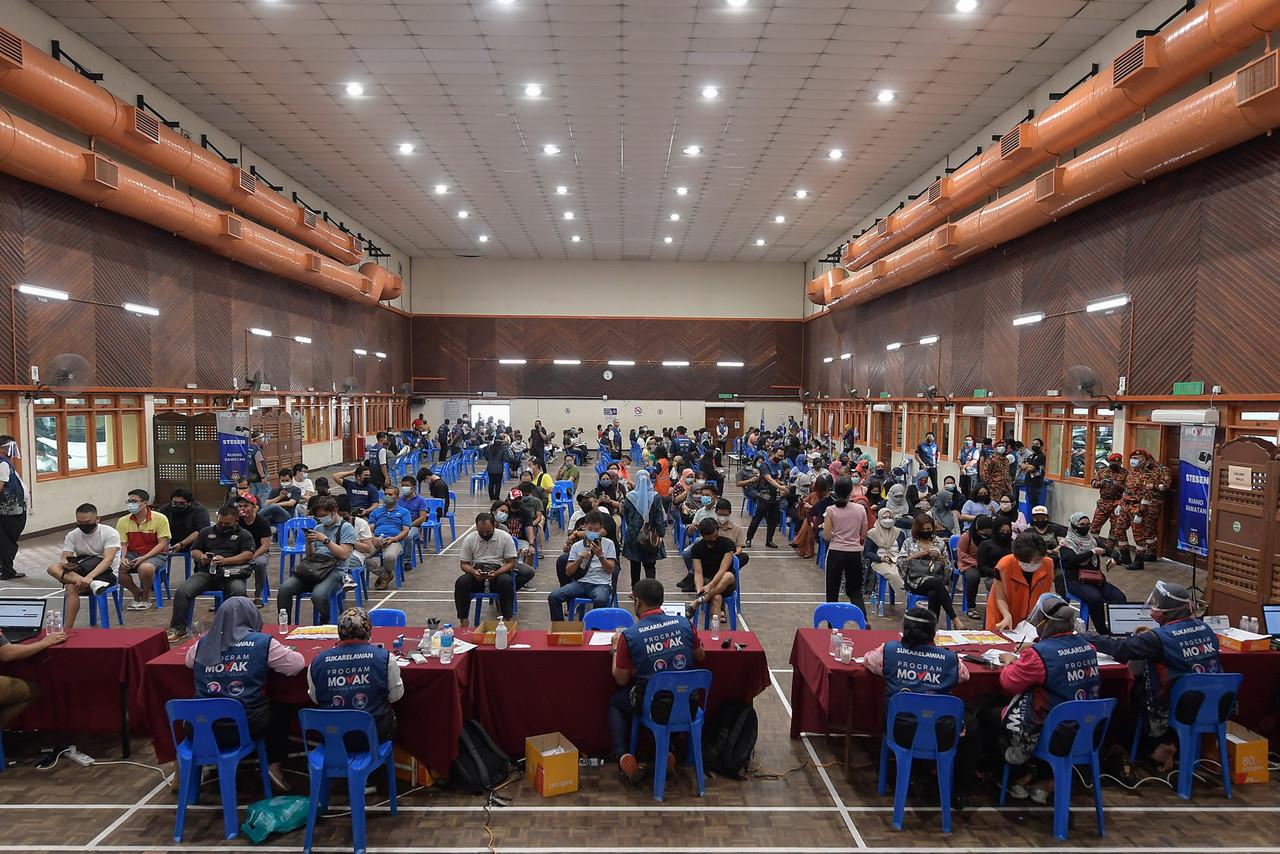 Petty traders receive their Covid-19 jabs at the Dewan Dato’ Ahmad Razali vaccination centre in Ampang under the Community Vaccine Mobilisation Programme by the national unity and housing and local government ministries. Photo: Bernama