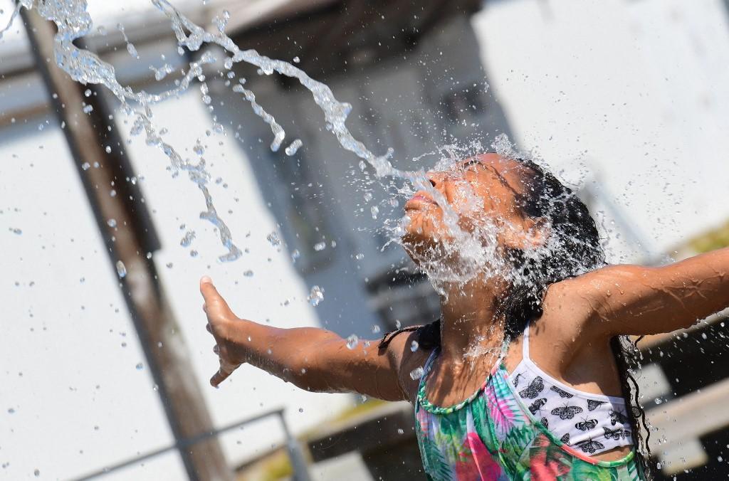 A girl cools off at a community water park on a scorching hot day in Richmond, British Columbia, June 29. Photo: AFP