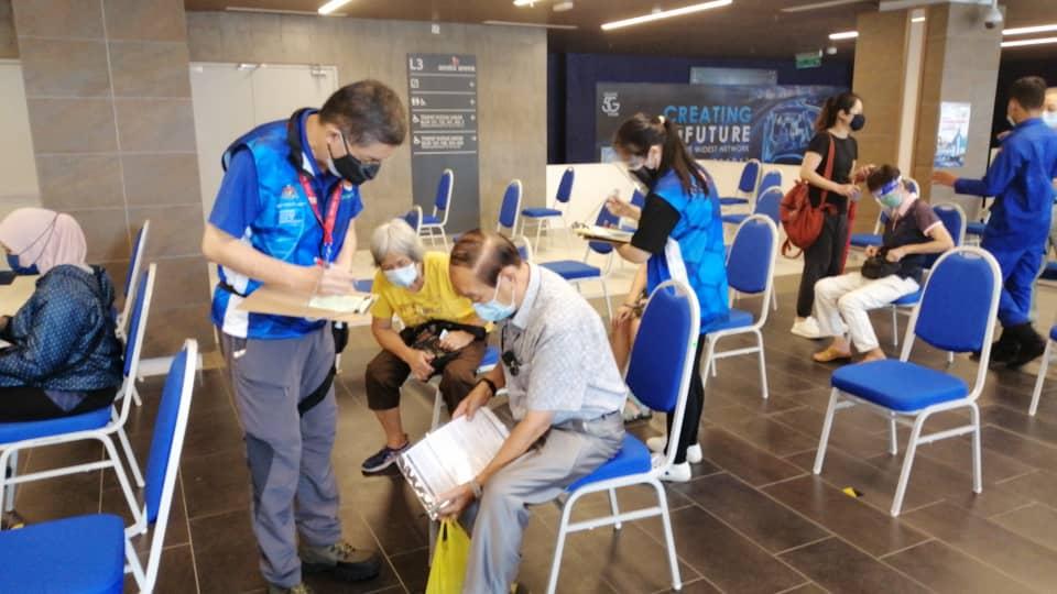 Volunteers help senior citizens register their details at a vaccination centre in the Klang Valley.