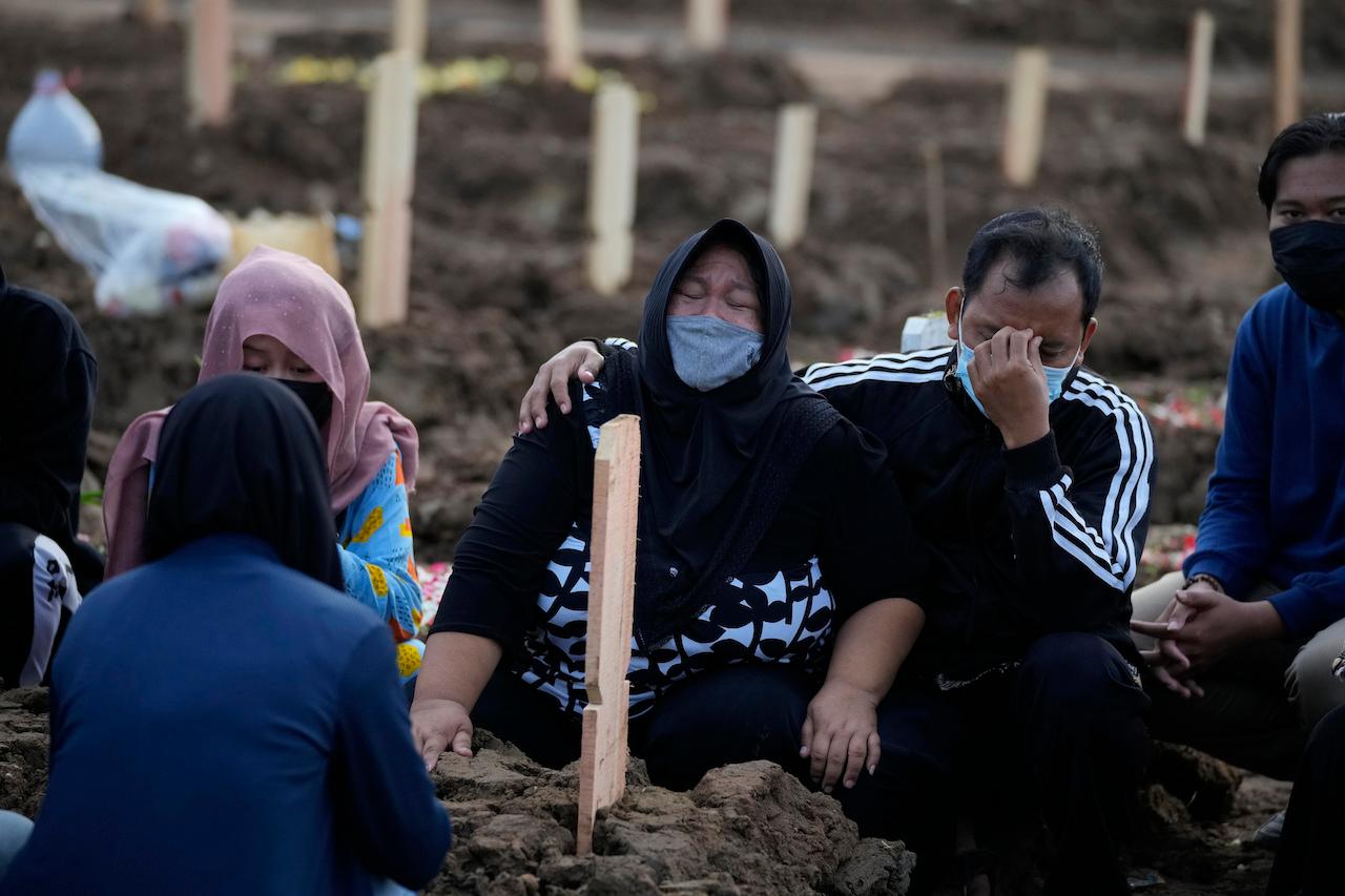 Family members weep during the burial of a relative at Rorotan Cemetery which is reserved for those who died of Covid-19, in Jakarta, Indonesia, July 1. Photo: AP