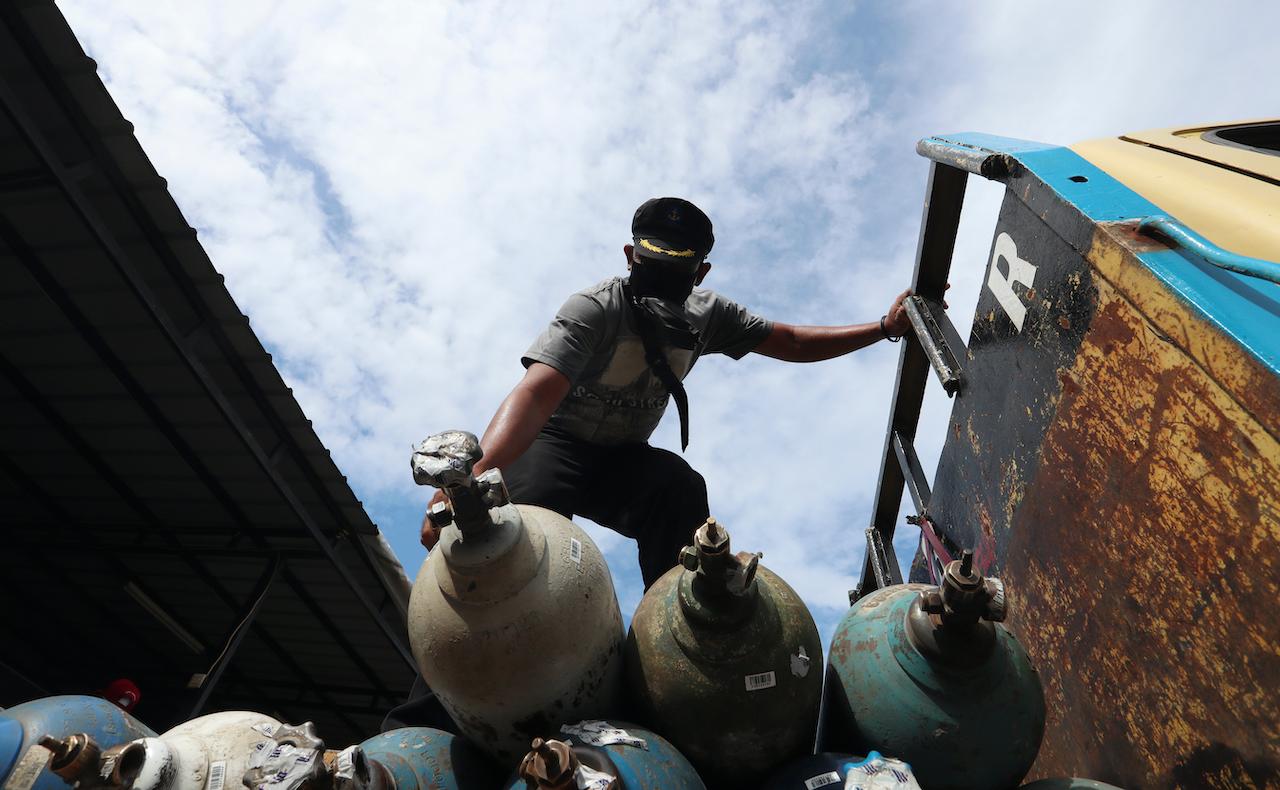 A worker loads oxygen tanks on a truck at a filling station in Jakarta, Indonesia, July 10. Photo: AP
