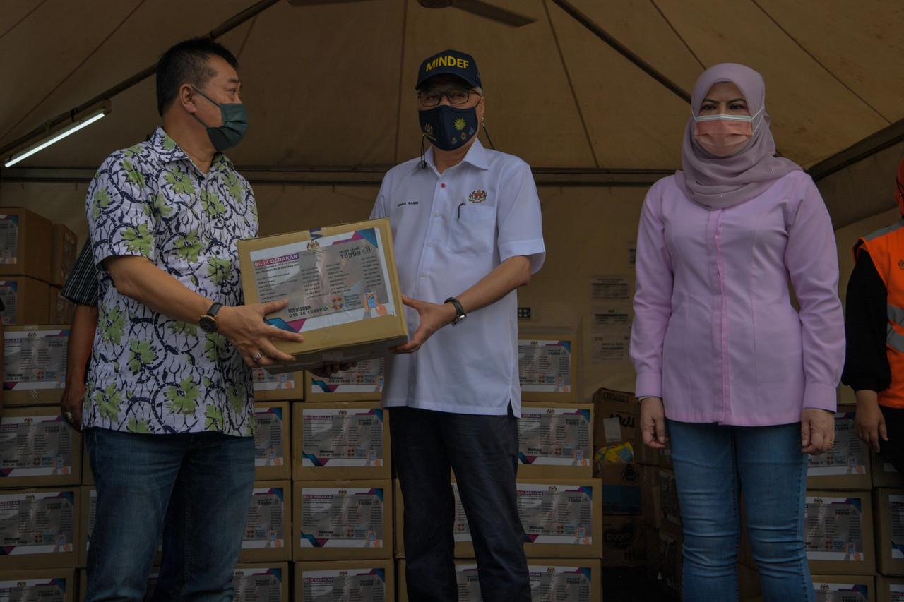 Timbalan Perdana Menteri Ismail Sabri Yaakob (tengah) menyampaikan bakul makanan kepada wakil penduduk semasa meninjau di PPR Kerinchi, Perumahan Pantai Permai yang dikenakan perintah kawalan pergerakan Diperketatkan (PKPD) hari ini.Turut hadir Menteri Pembangunan Wanita, Keluarga dan Masyarakat Rina Mohd Harun (kanan). Gambar: Bernama