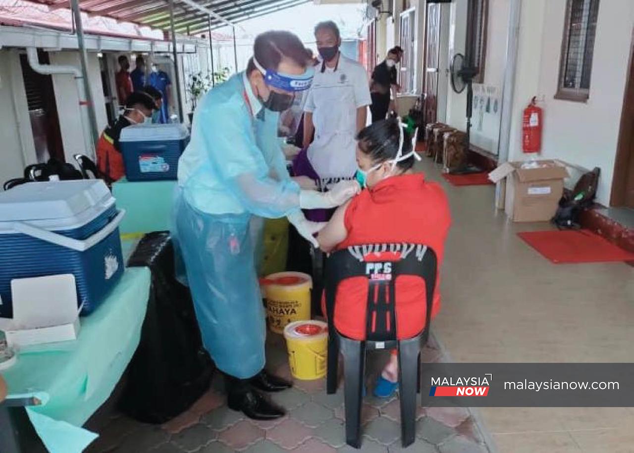 Inmates at the Sibu prison in Sarawak receive a first dose of Covid-19 vaccine.